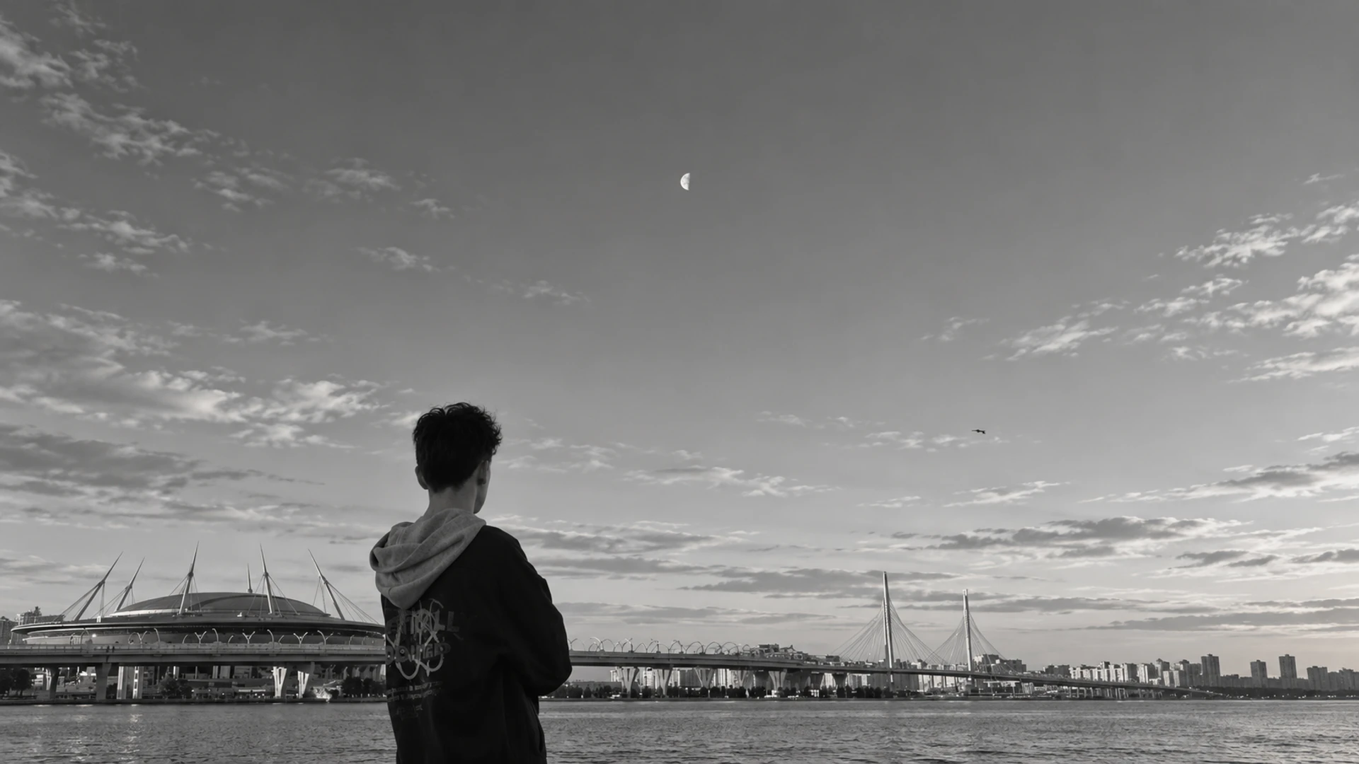 Danil looking across the waterfront towards the stadium and bridge, in black and white